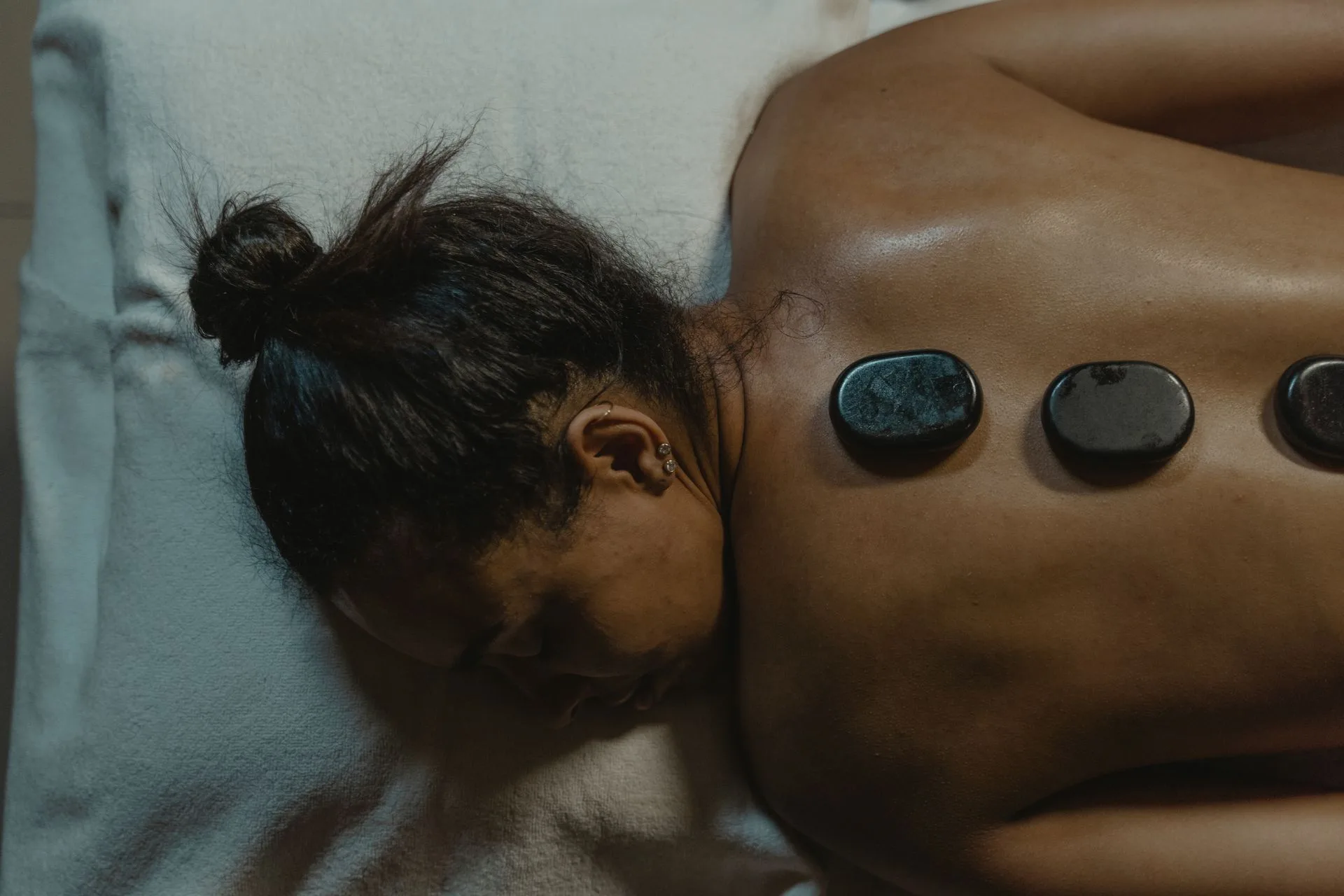 Smooth heated stones resting along a client's back during a hot stone massage